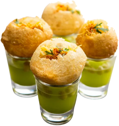 Four pani puri served in shot glasses of green pani, topped with sev and coriander