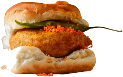 A vada pav: a spiced potato vada in a soft pav with garlic chutney and a green chilli